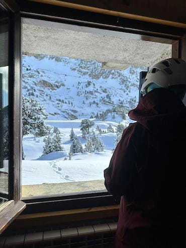 Vista des de la finestra d'un refugi durant una travessa d'esquí de muntanya a les muntanyes nevades dels Pirineus.