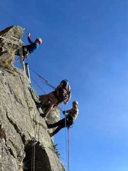 Trois grimpeurs descendant en rappel une paroi de calcaire près de Font-Romeu, initiation escalade en montagne.