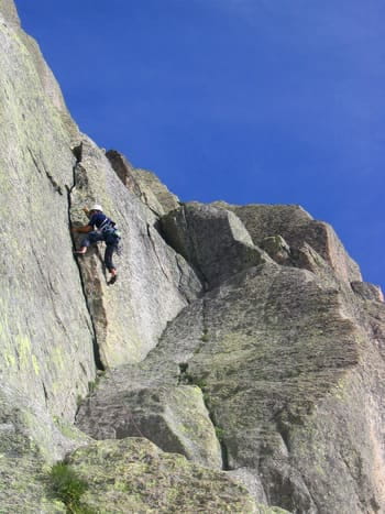 Un grimpeur en ascension sur une paroi rocheuse très verticale en Cerdagne, escalade en montagne.