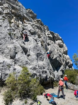 Groupe de grimpeurs escaladant une paroi rocheuse en calcaire à Font-Romeu, initiation escalade en Cerdagne et Capcir.