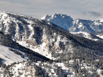 Domaine skiable enneigé de Masella avec vue sur les sapin de la station de ski et le sommet Tossa d'Alp.