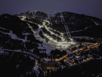 Photographie prise de nuit avec vue sur le domaine skiable de Masella avec ses pistes de ski éclairées pour la pratique nocturne.