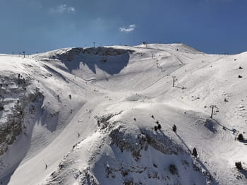 Photographie avec vue sur le domaine skiable de Masella avec ses pistes de ski  et ses remontés mécaniques dans un décors enneigé.