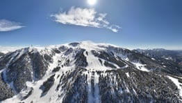 Domaine skiable de Masella, vue sur les montagne, les sapins et une grande piste de descente.