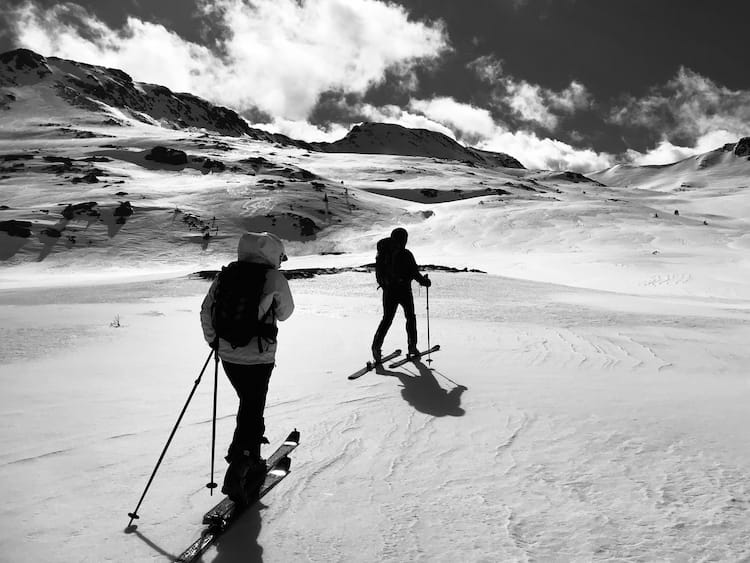 Deux skieurs pratiquant le ski de randonnée dans un paysage montagneux enneigé sur les hauteurs de Bolquère. Des sorties ski de rando / alpinisme accompagné d'un guide de haute montagne sans les Pyrénées au départ de Cerdagne / Capcir depuis font-romeu, les Angles, Formiguères, Porté Puymorens, Cambre d’aze ...