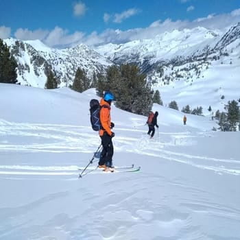 Groupe de skieurs descendant une pente enneigée en hors-piste dand la Vallée du Galbe après une ascension en ski de randonnée accompagné par un guide de haute montagne dans les pyrénées. Après l'acsention du Pic de l'Homme Mort par l'arête en alpinisme. Possibilité de départ pour une session ski rando au départ de Font-Romeu, les Angles, Formiguères, Porté Puymorens, Cambre d’aze et bien d'autres.