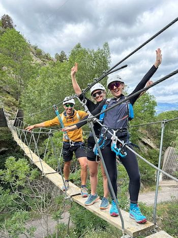 Trois amis joyeux traversant une passerelle de la via ferrata de Llo, Pyrénées-Orientales