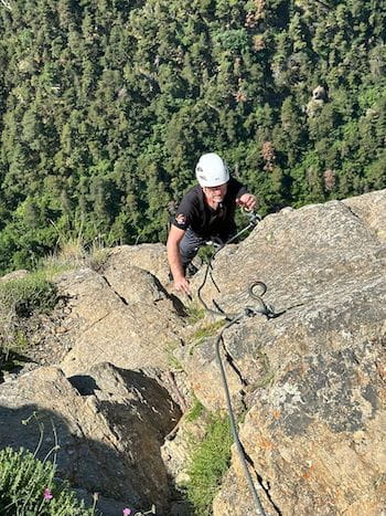 Participant évoluant en escaladant la via ferrata des Pyrénées-Orientales près de Font-Romeu