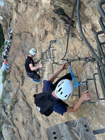 Deux personnes escaladant les marches de la via ferrata de Llo dans les Pyrénées-Orientales, 66