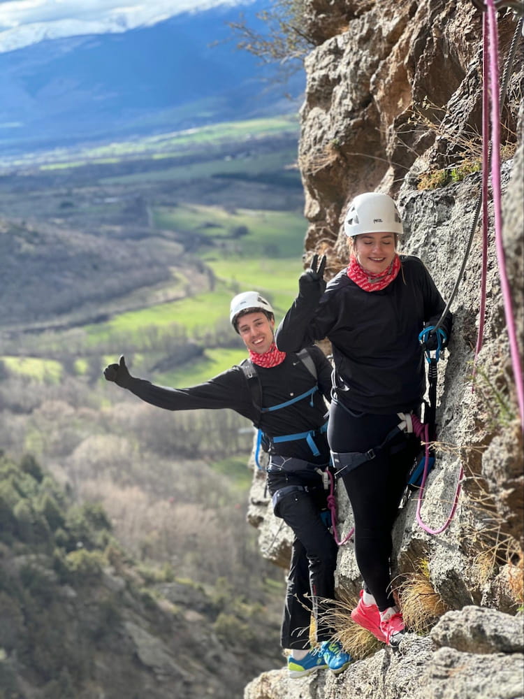 Pratiquants souriants en baudrier, accrochés à câble via, paroi rocheuse, Pyrénées, Font-Romeu.