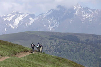 VTTAE sur sentier, herbe, panorama montagnes Pyrénées, neige printemps, Font-Romeu.