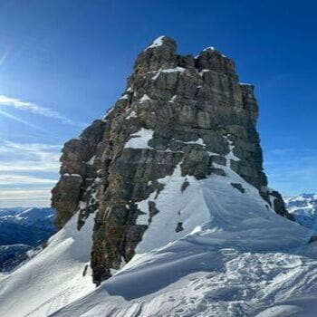 Montagne enneigée dans le Queyras avec un skieur de randonnée admirant la vue au sommet.