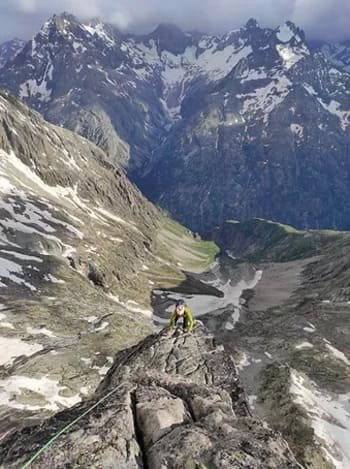 Alpiniste encordé gravissant une paroi pour atteindre le sommet, Pyrénées. Alpiniste encordé gravissant une paroi pour atteindre le sommet, Pyrénées.
