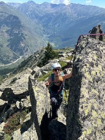 Femme alpiniste en baudrier et casque, encordée, atteignant le sommet dans les Pyrénées-Orientales (66) près de Font-Romeu. Femme alpiniste en baudrier et casque, encordée, atteignant le sommet dans les Pyrénées-Orientales (66) près de Font-Romeu.