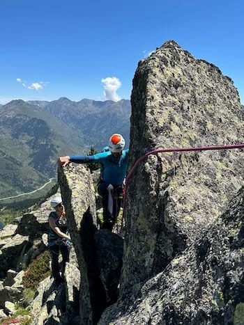 Alpinistes encordés grimpant entre deux rochers au sommet des Pyrénées près de Font-Romeu. Alpinistes encordés grimpant entre deux rochers au sommet des Pyrénées près de Font-Romeu.