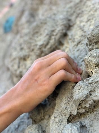 École d'escalade, main accroché à la falaise près de Font-Romeu 66 École d'escalade, main accroché à la falaise près de Font-Romeu 66