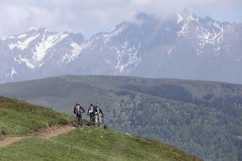 VTTAE sur sentier, herbe, panorama montagnes Pyrénées, neige printemps, Font-Romeu. VTTAE sur sentier, herbe, panorama montagnes Pyrénées, neige printemps, Font-Romeu.